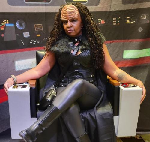 Star Trek Cruise 2023<br><br>Allie sitting in the Enterprise Captain's chair in full Klingon makeup and uniform.