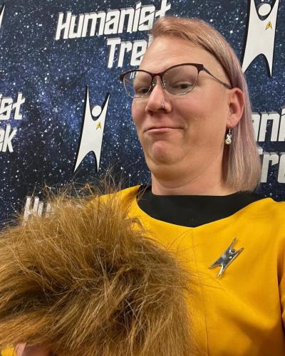 Sarah in Gold Star Trek TOS uniform holding a tribble.