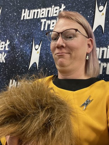 Sarah holds a large, furry, brown tribble