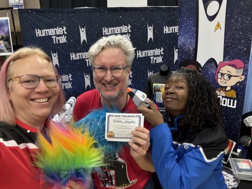 Sarah and Allie wearing Lower Decks uniforms with the President of the Continuummm. The tribbles are multiplying already.